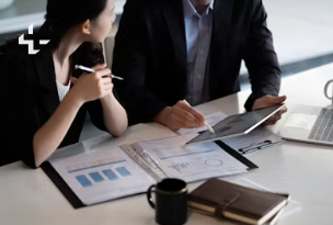 Two GAMA consultants reviewing a client's plans and figures at a table